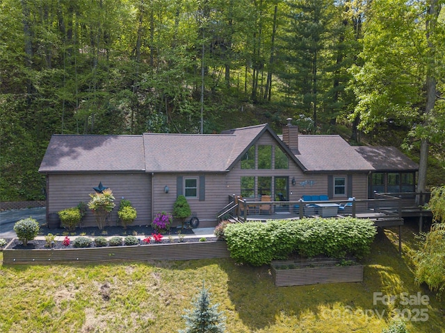 14 Bellewood Dr, Maggie Valley, NC 28751 - view of front of home featuring a chimney, a wooden deck, a shingled roof, and a vegetable garden