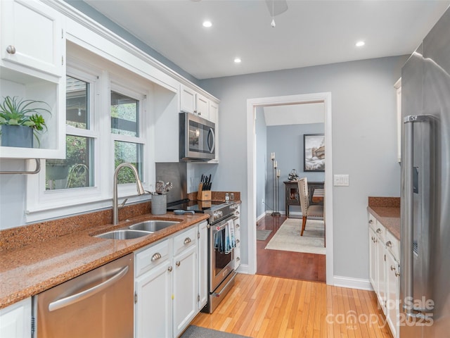 14 Bellewood Dr, Maggie Valley, NC 28751 - kitchen featuring appliances with stainless steel finishes, a sink, light wood-style floors, white cabinets, and light stone counters