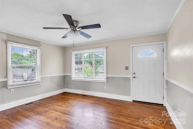 foyer featuring plenty of natural light, hardwood / wood-style flooring, a ceiling fan, a textured ceiling, and crown molding