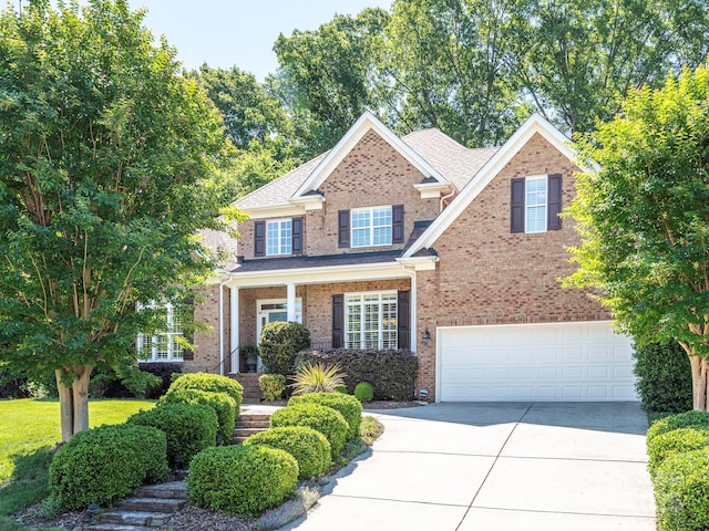 7040 Edenderry Dr, Charlotte, NC 28270 - view of front facade with driveway, brick siding, an attached garage, and roof with shingles