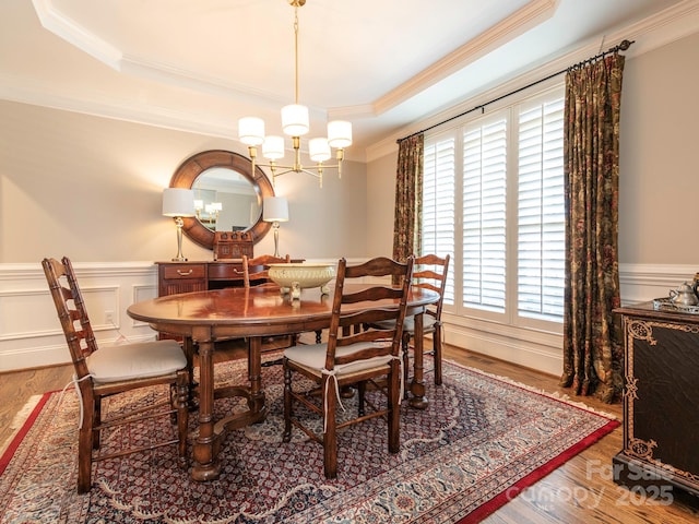 7040 Edenderry Dr, Charlotte, NC 28270 - dining space featuring a chandelier, ornamental molding, wainscoting, wood finished floors, and a raised ceiling
