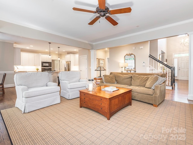 7040 Edenderry Dr, Charlotte, NC 28270 - living area featuring light wood finished floors, a ceiling fan, ornamental molding, decorative columns, and stairs