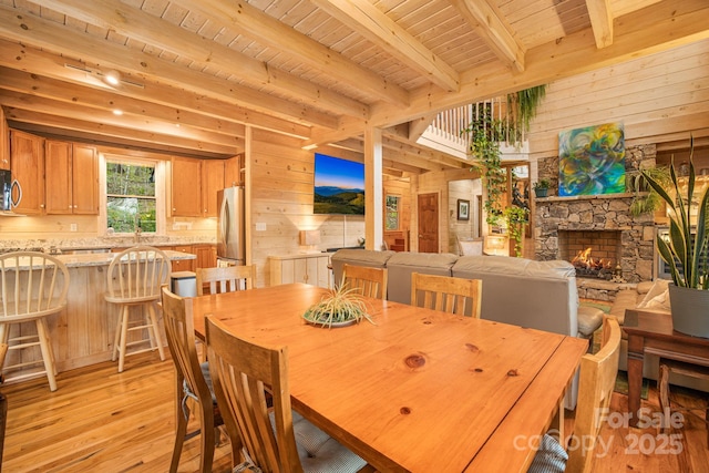 60 Laurel Ln, Mars Hill, NC 28754 - dining space with light wood finished floors, beam ceiling, wooden walls, wood ceiling, and a fireplace