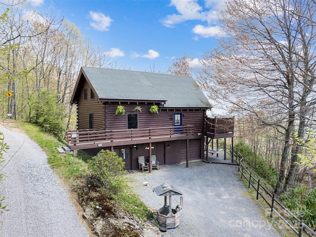 16 Sutton Knob Rd, Maggie Valley, NC 28751 - rear view of house with log siding, gravel driveway, a garage, roof with shingles, and a wooden deck