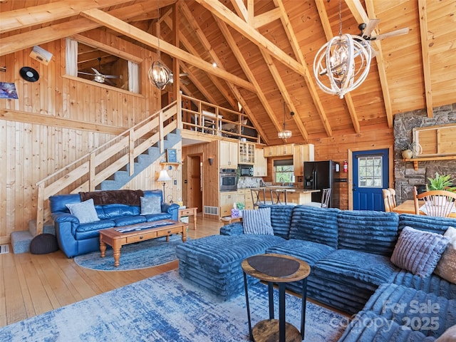 16 Sutton Knob Rd, Maggie Valley, NC 28751 - living area with wood walls, high vaulted ceiling, stairway, light wood-style flooring, and beam ceiling