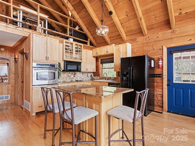 16 Sutton Knob Rd, Maggie Valley, NC 28751 - kitchen with black appliances, wood walls, light wood finished floors, plenty of natural light, and beamed ceiling