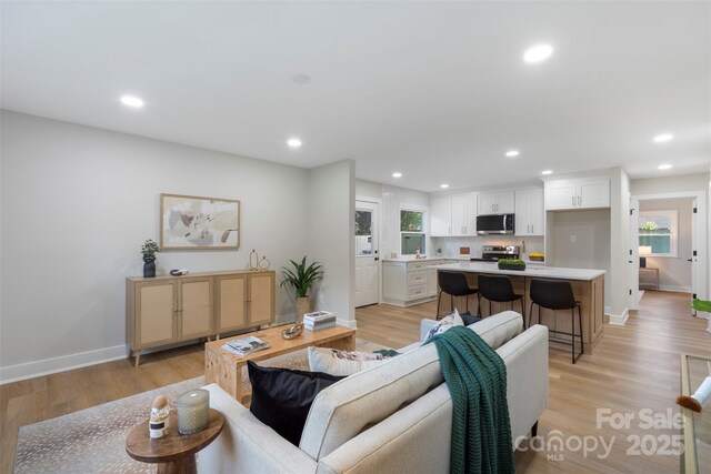 4042 Uppergate Ln, Charlotte, NC 28215 - living room featuring healthy amount of natural light, recessed lighting, baseboards, and light wood finished floors