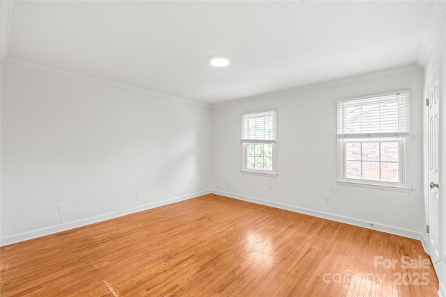 unfurnished room with light wood-style floors, crown molding, and baseboards