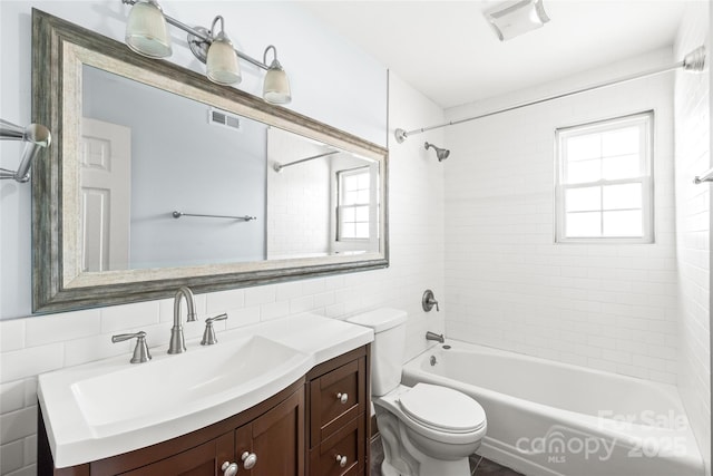 full bath with toilet, vanity, washtub / shower combination, and tile walls