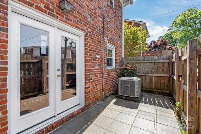 view of patio / terrace featuring cooling unit, french doors, and fence