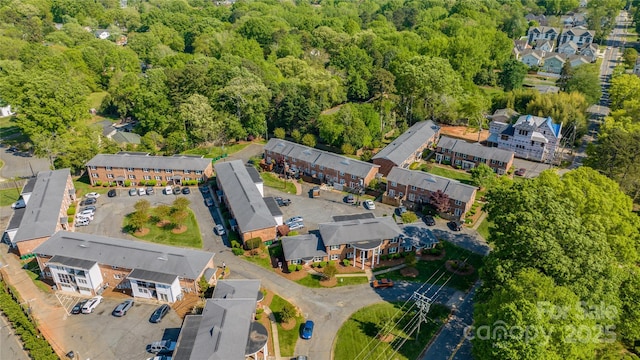 view of property location featuring a forest and nearby suburban area