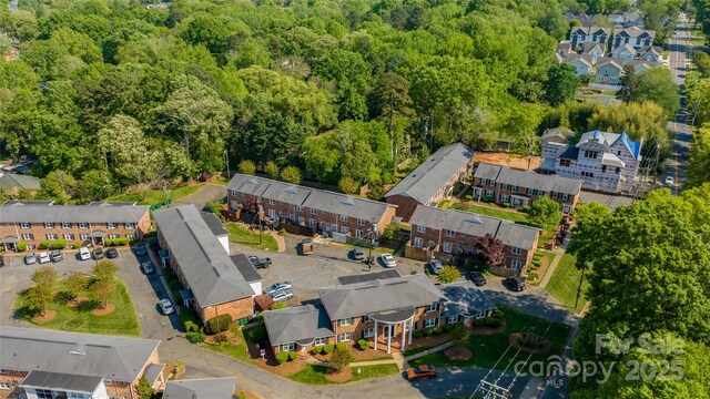 aerial overview of property's location with a forest and nearby suburban area