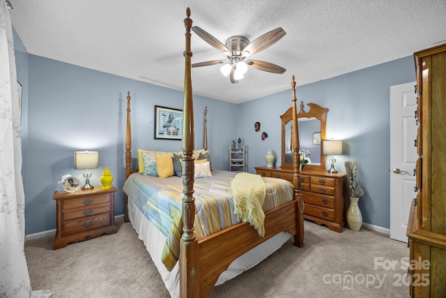 carpeted bedroom featuring a textured ceiling, a ceiling fan, and baseboards