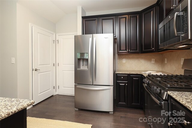 1809 Evergreen Dr, Charlotte, NC 28208 - kitchen with appliances with stainless steel finishes, dark wood-style flooring, light stone countertops, backsplash, and dark cabinetry