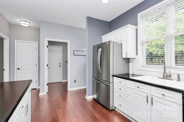 kitchen with a sink, freestanding refrigerator, dark wood finished floors, and baseboards