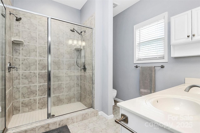 full bath with a shower stall, double vanity, toilet, and marble look tile flooring
