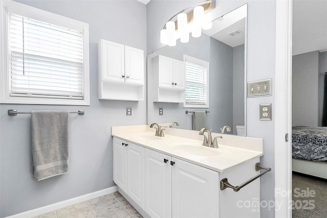full bathroom with baseboards, connected bathroom, double vanity, and marble look tiles