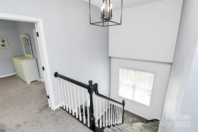 stairway with carpet, a chandelier, and baseboards