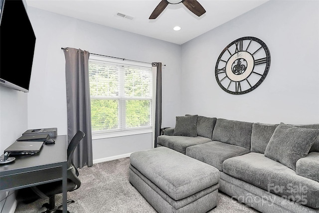 carpeted office space with ceiling fan and baseboards