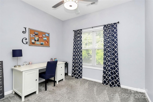 carpeted office space with a ceiling fan and baseboards
