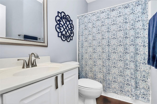 bathroom featuring toilet, vanity, and a shower with curtain