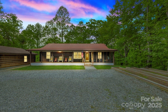 909 Pearson Falls Rd, Saluda, NC 28773 - view of front of home featuring driveway, metal roof, and a sunroom