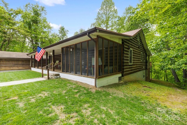 909 Pearson Falls Rd, Saluda, NC 28773 - rear view of property featuring a sunroom, a yard, and metal roof
