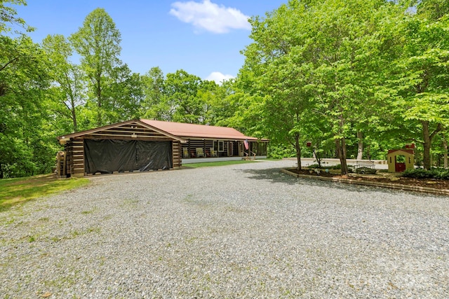 909 Pearson Falls Rd, Saluda, NC 28773 - view of front of home with an outdoor structure, driveway, log siding, and a garage
