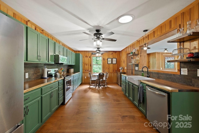 909 Pearson Falls Rd, Saluda, NC 28773 - kitchen with green cabinets, stainless steel appliances, a sink, backsplash, and wooden counters