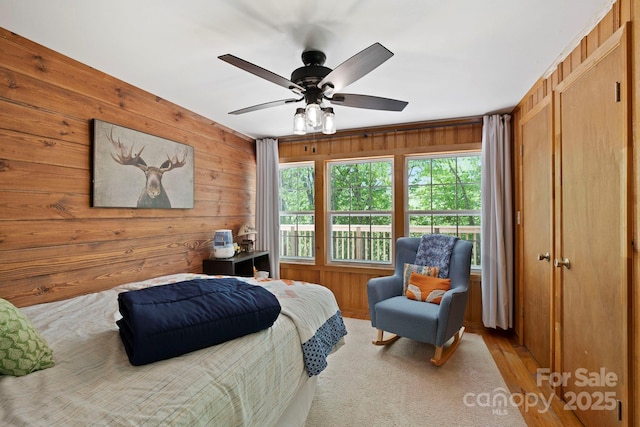 909 Pearson Falls Rd, Saluda, NC 28773 - bedroom with wooden walls, ceiling fan, and wood finished floors