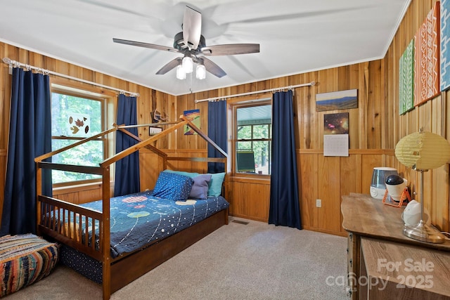 909 Pearson Falls Rd, Saluda, NC 28773 - bedroom featuring multiple windows, wooden walls, carpet floors, crown molding, and ceiling fan