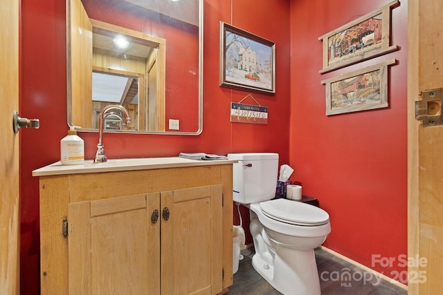 909 Pearson Falls Rd, Saluda, NC 28773 - half bath with wood finished floors, toilet, vanity, and baseboards
