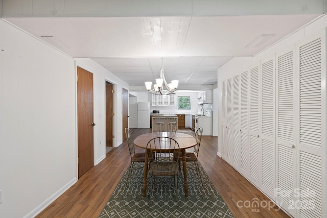 909 Pearson Falls Rd, Saluda, NC 28773 - dining area with a chandelier, dark wood finished floors, and baseboards