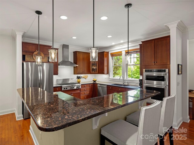 9 Dearborn St, Asheville, NC 28803 - kitchen with wall chimney exhaust hood, a sink, appliances with stainless steel finishes, backsplash, and baseboards