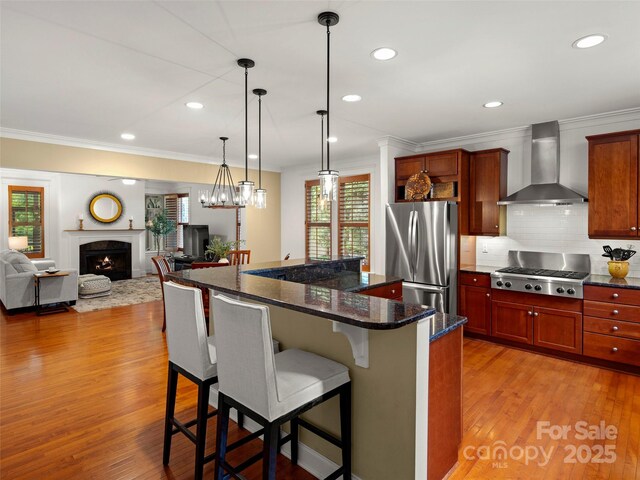 9 Dearborn St, Asheville, NC 28803 - kitchen featuring wall chimney exhaust hood, stainless steel appliances, ornamental molding, tasteful backsplash, and a breakfast bar