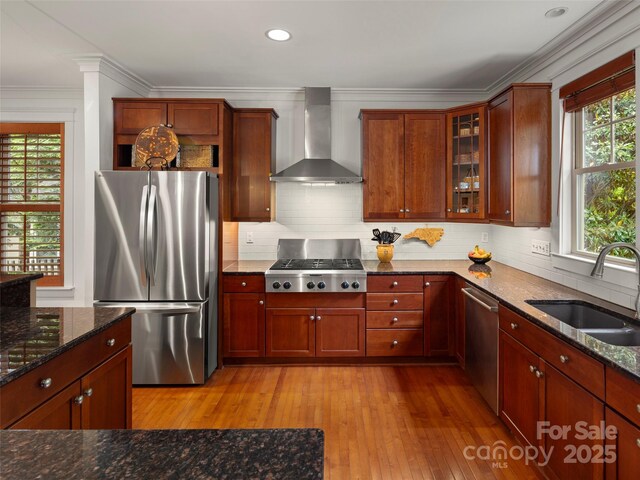 9 Dearborn St, Asheville, NC 28803 - kitchen featuring stainless steel appliances, wall chimney range hood, a sink, ornamental molding, and light wood-style floors