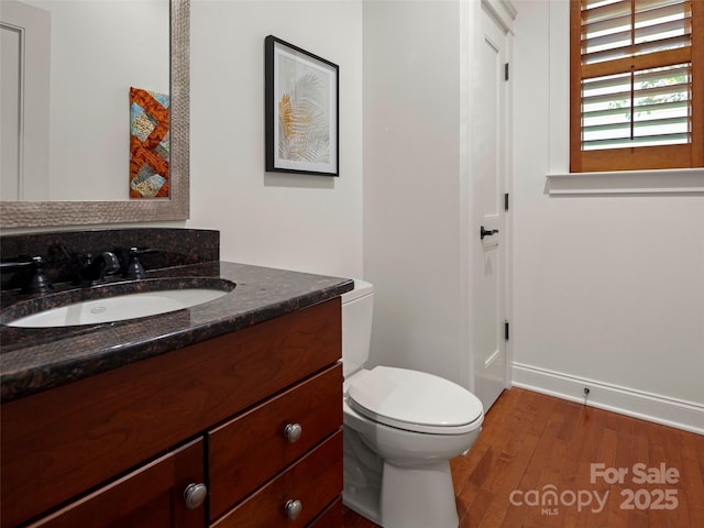 9 Dearborn St, Asheville, NC 28803 - half bathroom featuring wood finished floors, vanity, toilet, and baseboards
