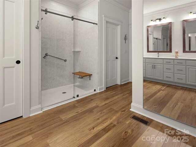 9 Dearborn St, Asheville, NC 28803 - bathroom with crown molding, a stall shower, wood finished floors, vanity, and baseboards