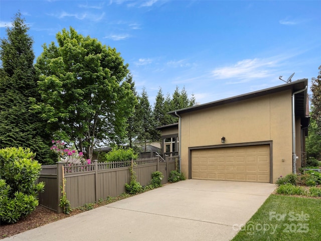 9 Dearborn St, Asheville, NC 28803 - view of home's exterior with fence, driveway, stucco siding, and a garage