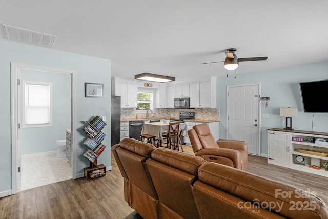 772 Austin Rd, New London, NC 28127 - living room with wood finished floors, baseboards, and ceiling fan