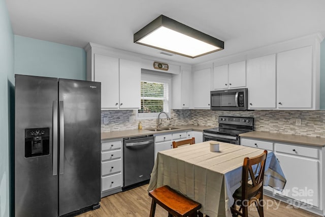 772 Austin Rd, New London, NC 28127 - kitchen with stainless steel appliances, a sink, white cabinetry, and decorative backsplash