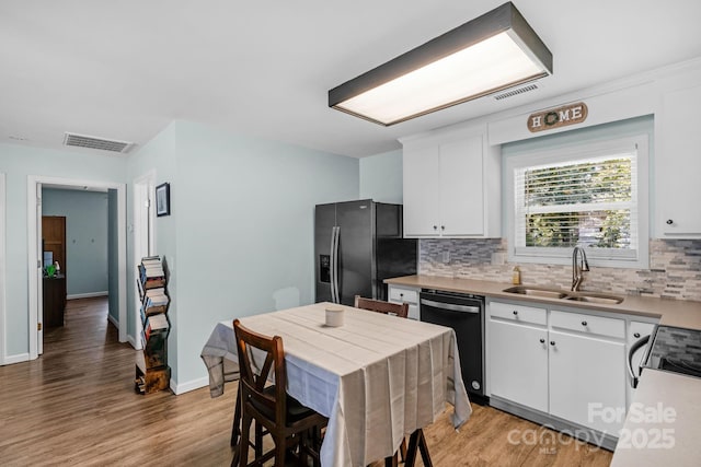 772 Austin Rd, New London, NC 28127 - kitchen with a sink, stainless steel fridge with ice dispenser, dishwashing machine, tasteful backsplash, and white cabinets