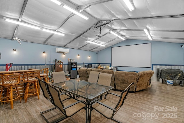 772 Austin Rd, New London, NC 28127 - dining room featuring light wood-style flooring, a wall unit AC, and vaulted ceiling