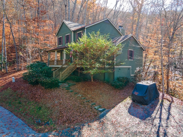196 Juneberry Ln, Tuckasegee, NC 28783 - view of property exterior featuring a chimney, stairway, covered porch, and a forest view