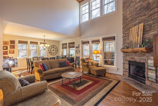 196 Juneberry Ln, Tuckasegee, NC 28783 - living area featuring a chandelier, a stone fireplace, wood finished floors, and a high ceiling
