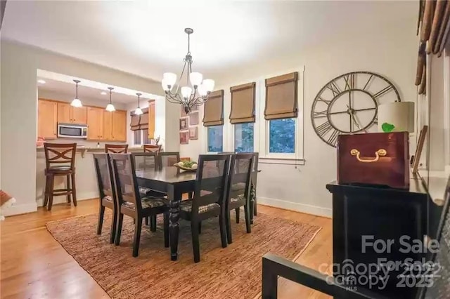 196 Juneberry Ln, Tuckasegee, NC 28783 - dining area featuring a chandelier, light wood-style floors, and baseboards