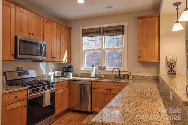 196 Juneberry Ln, Tuckasegee, NC 28783 - kitchen featuring appliances with stainless steel finishes, a sink, recessed lighting, light stone counters, and hanging light fixtures