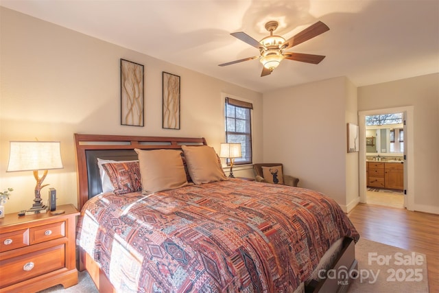 196 Juneberry Ln, Tuckasegee, NC 28783 - bedroom with light wood-type flooring, connected bathroom, ceiling fan, and baseboards