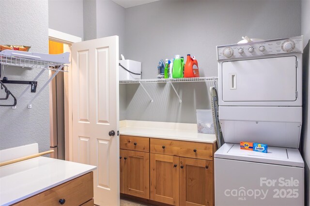196 Juneberry Ln, Tuckasegee, NC 28783 - clothes washing area with estacked washer and dryer, cabinet space, and a textured wall