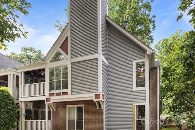 2502 Cranbrook Ln Unit 8, Charlotte, NC 28207 - view of home's exterior with brick siding, a sunroom, a chimney, and ceiling fan